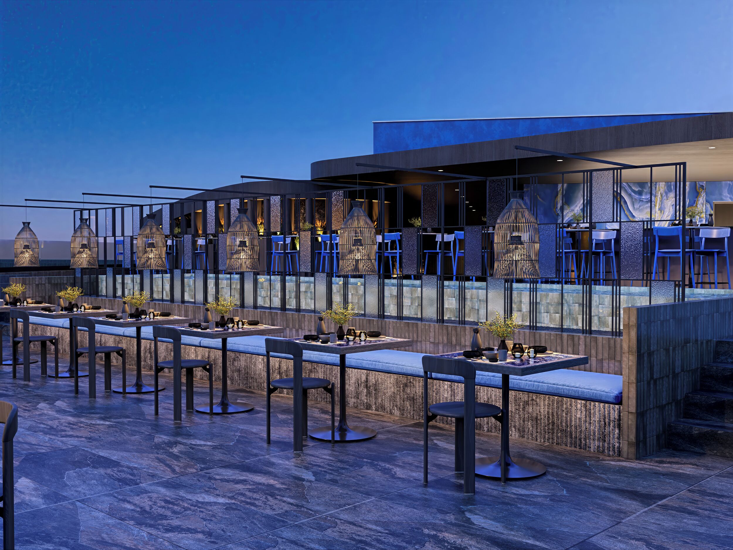 An outdoor dining area with modern tables and chairs, a pool, and a view of the city skyline.