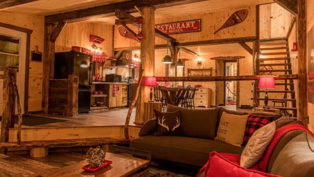 Ein rustikales Interieur mit einer Holzesstge, einer Treppe und einer gemütlichen Sitzecke mit Kamin.