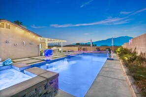 A swimming pool with a net, a covered seating area, and a mountain view in the background. - 3BR Desert Escape , Pool, Views & Mini Golf (Desert Hot Springs)