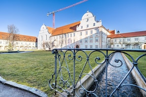 A historic building with a red roof, a large white dome, and a construction crane in the background.
