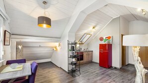 Un espacio tipo loft con comedor, cocina y un ventanal grande.