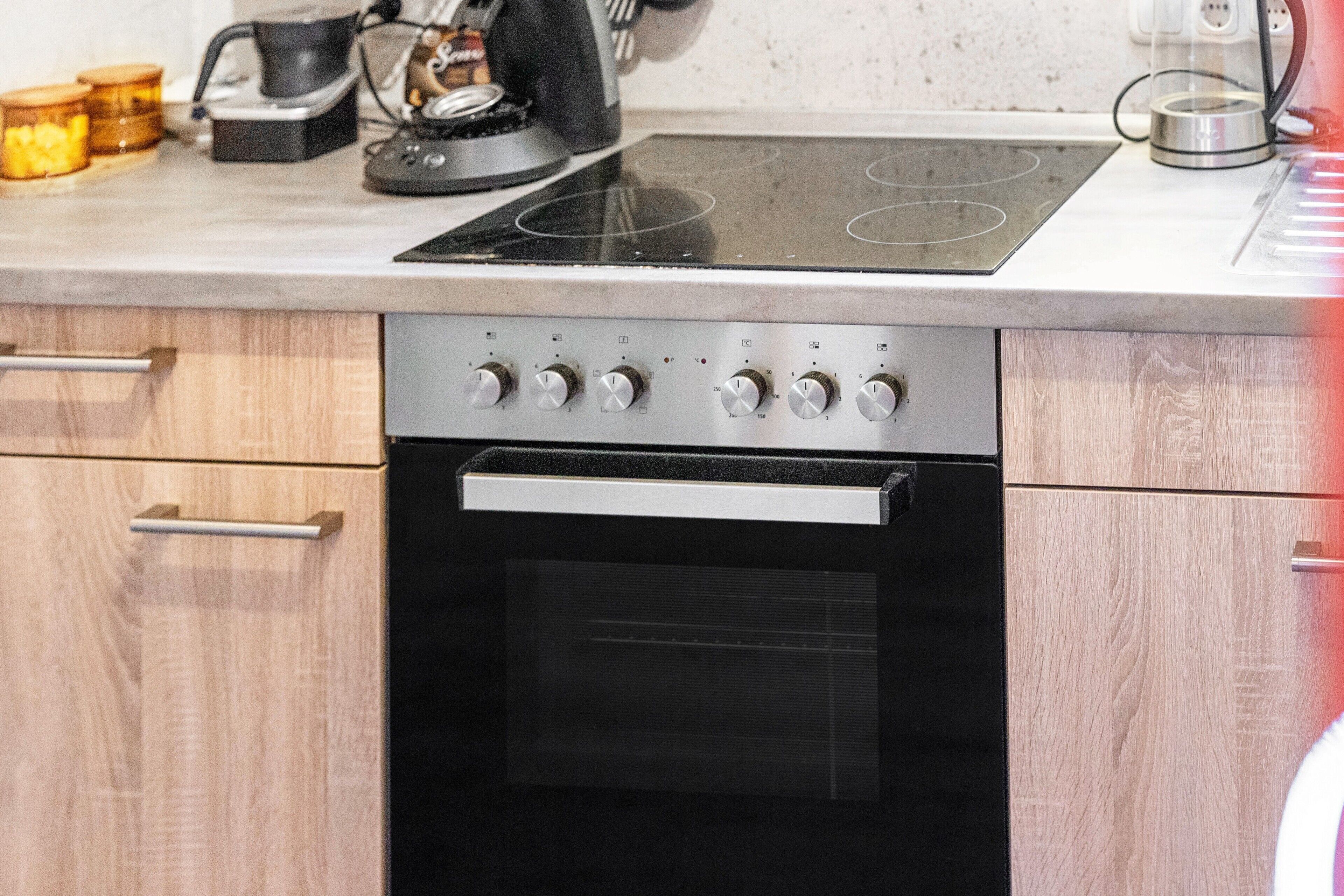 Una cocina equipada con horno integrado, placa de cocción y microondas.