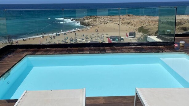 A pool with a view of a beach and ocean. - atico azul (Tangier)