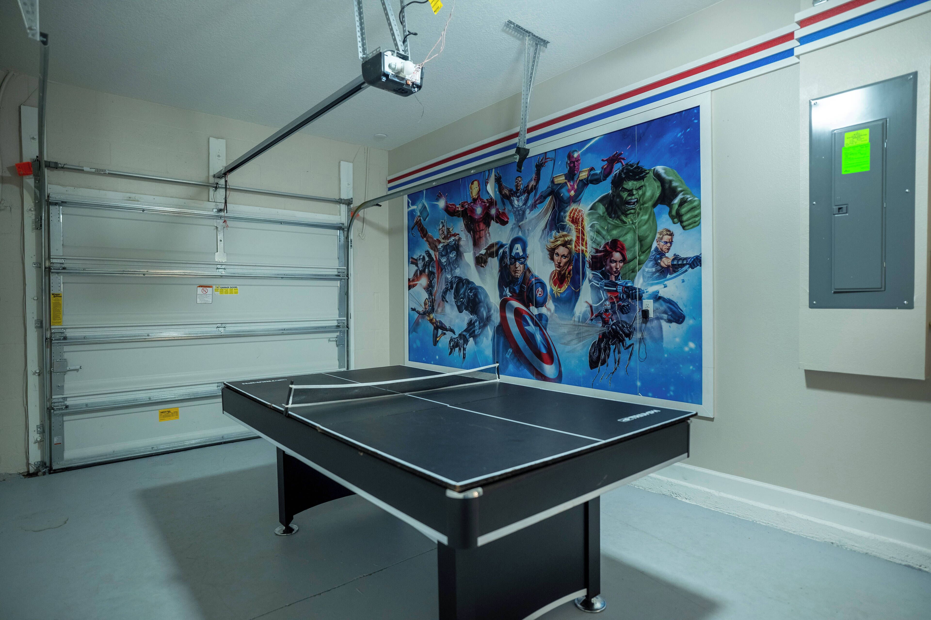Een tafeltennistafel in een kamer met een grote muurschildering met het thema Avengers.