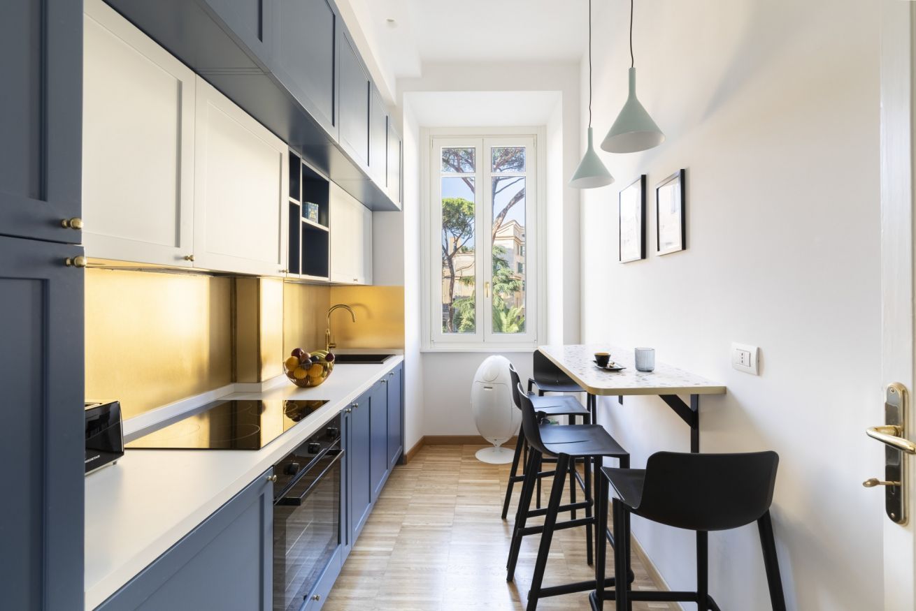 Una cocina moderna con comedor, que cuenta con un ventanal, luces colgantes y vistas al exterior.