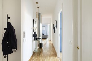 A hallway with a coat rack, a mirror, and a door leading to a room. - Charming home near San Giovanni (Roma)