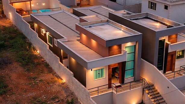 A modern residential complex with multiple connected buildings, a rooftop pool, and a staircase leading to the upper floors. - Casa confortável estilo americana.Perto da praia e perto do centro. (Rio das ostras)