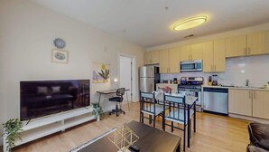 Un appartement moderne comprenant un salon, un coin repas et une cuisine.