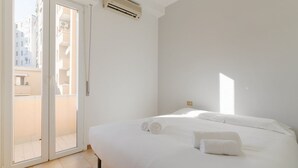 A hotel room with a bed, a sliding glass door to a balcony, and an air conditioning unit. - GuestHost - A comfortable and welcoming 50 square meters apartment, perfect for four people, located on the eighth floor of a building (NO elevator).The property is located in the Washington neighborhood, a lively and well-equipped area of ​​Milan fi (Milan)