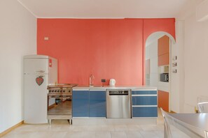 A compact kitchen with a white refrigerator, a stove, a dishwasher, and a sink.