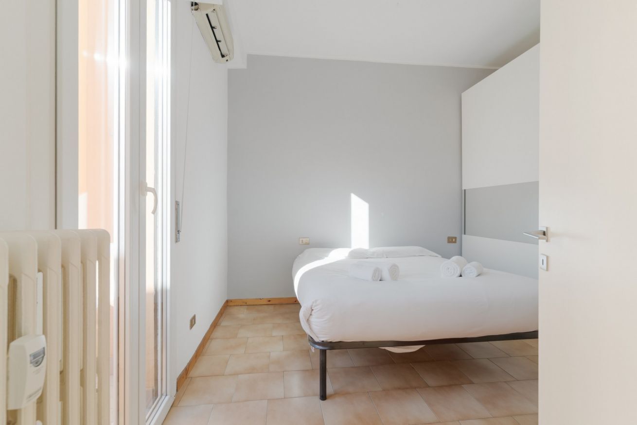 Une chambre à coucher avec un lit, un radiateur et une fenêtre.