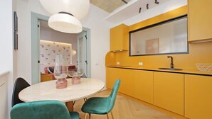 Una cocina moderna con armarios amarillos, una mesa redonda y sillas color aguamarina.
