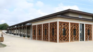 A modern building with large windows and wooden lattice doors.