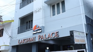 A multi-story building with the sign "Lakshmi Palace" indicating it is a hotel. There are closed gates at the entrance, and a signboard stating "Rooms available". - Lakshmi Palace Near MGR Bus Stand (Madurai)
