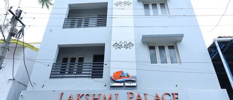 A building with the sign "Lakshmi Palace" and a logo above the sign.