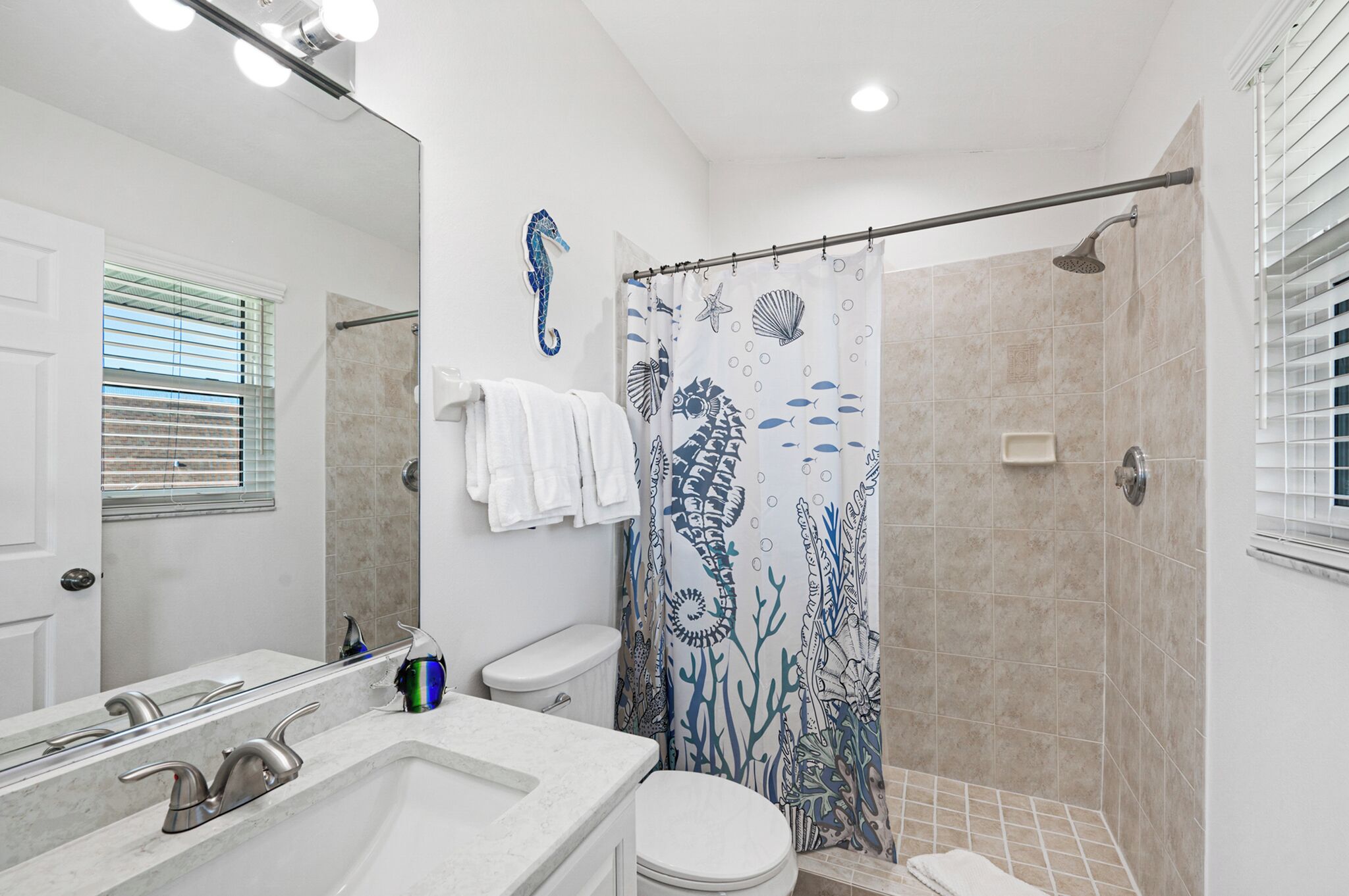 A bathroom with a shower, toilet, and sink.