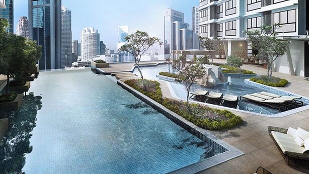 A rooftop infinity pool with lounge chairs and a cityscape view. - Signature Apartment at 188 Suites (Kuala Lumpur)