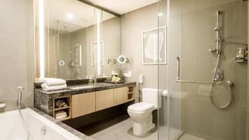 A modern bathroom with a glass shower enclosure, a bathtub, a toilet, and a vanity with a mirror.