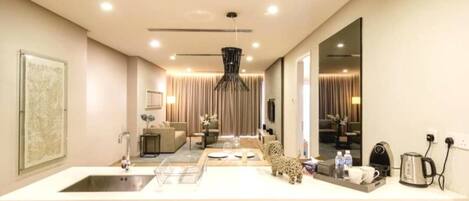 A modern kitchen with a large island, a built-in dishwasher, and a coffee maker.