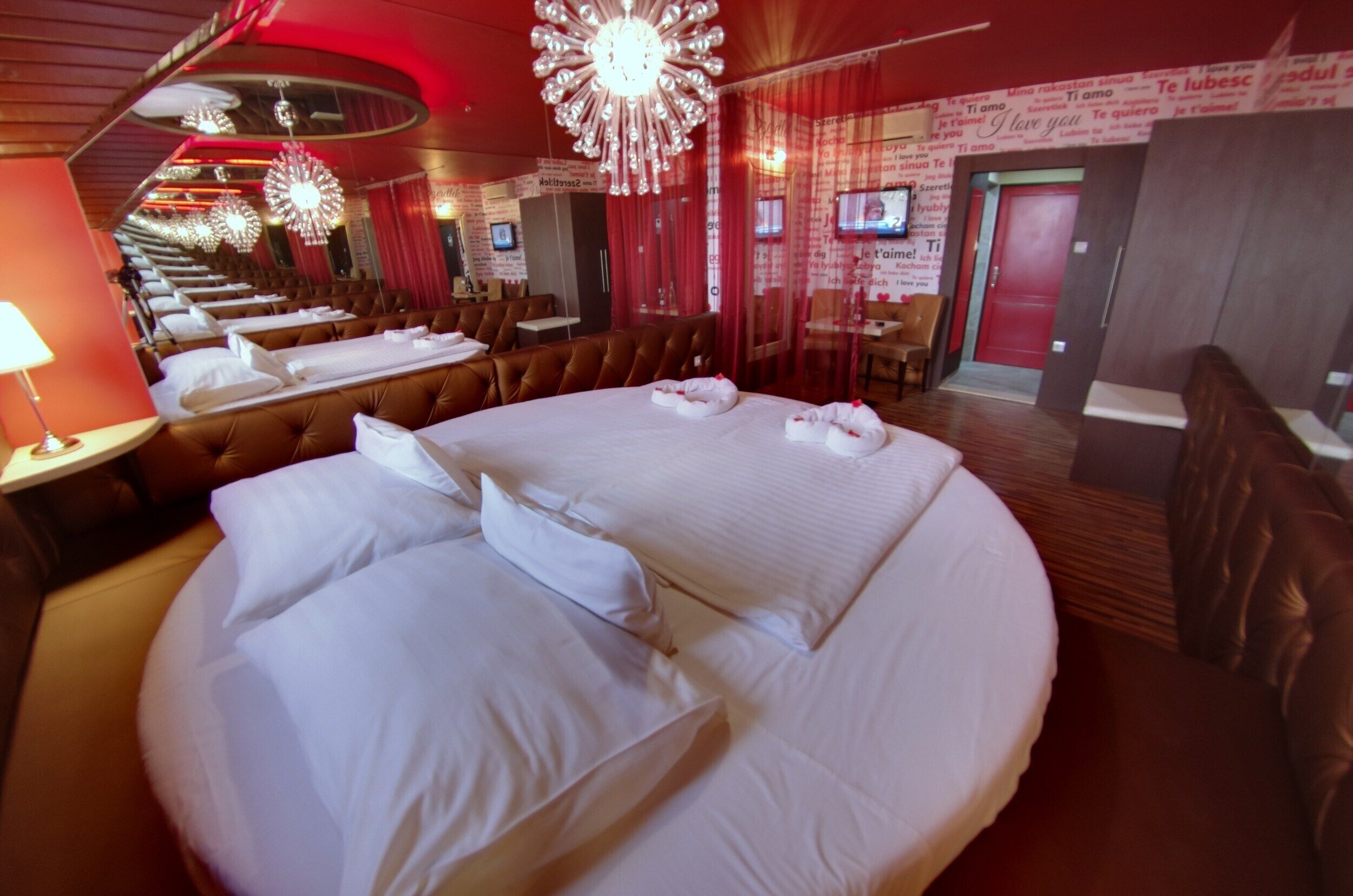 Una habitación de hotel con una cama grande, varias zonas de estar y un televisor.