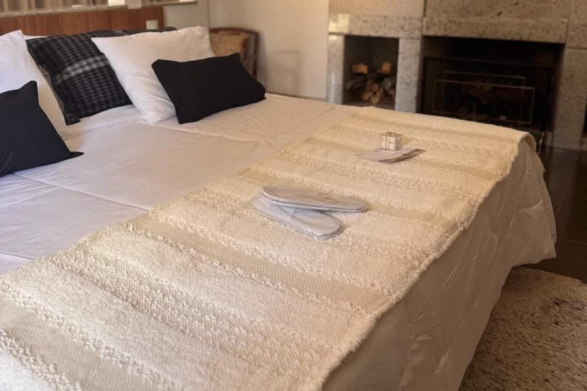 Ein Hotelzimmer mit einem großen Bett, einem Kamin und Blick ins Freie.