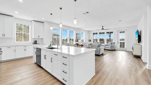 A modern kitchen with white cabinetry, a central island, and pendant lighting. - The Grove Dogwood 321 - 4 Bedrooms - Lazy River - Seascape Resort (Miramar Beach)