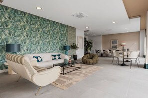 Ein modernes Wohnzimmer mit Sofa, Couchtisch und Essbereich mit Stühlen und Tisch.