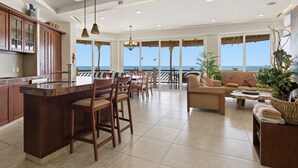 A spacious living area with a kitchen, large windows, and a view of the ocean. - Four bedroom, ocean front, Vivo Resorts, Palmarito (Bajos de Chila)
