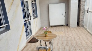 A dining area with a marble wall, a white door, and a wooden floor. - Luxury villa (Douala)