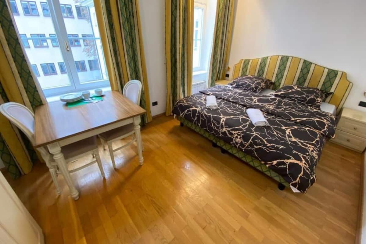 A bedroom with a bed, a table, and chairs.