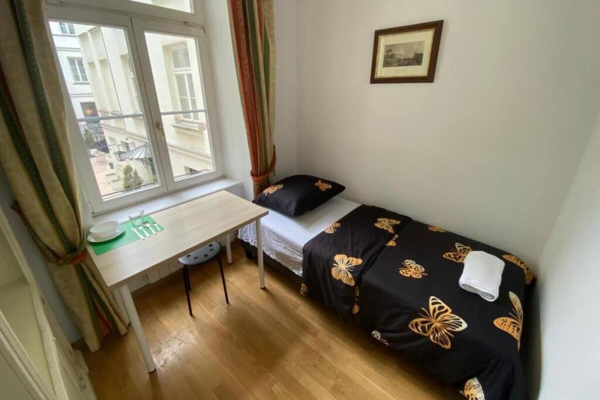 A small room with a bed, a desk, and a window.