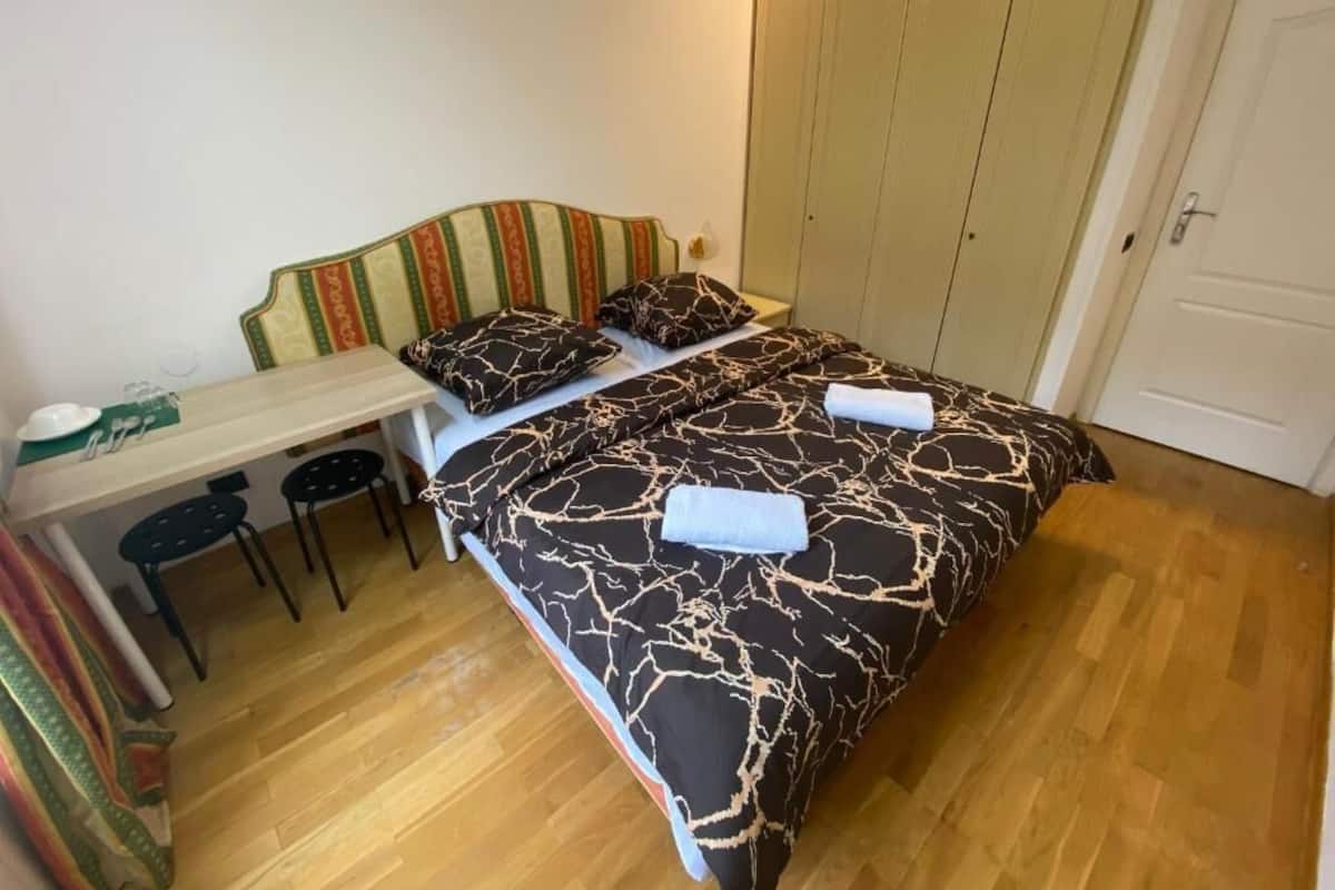 A bedroom with a bed, a desk, and two chairs.