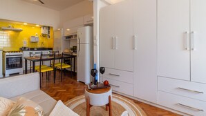 A compact living space with a kitchenette, dining area, and a seating area with a sofa and a small round table. - 300 Meters From Copacabana Beach Nsc909 (Rio de Janeiro)