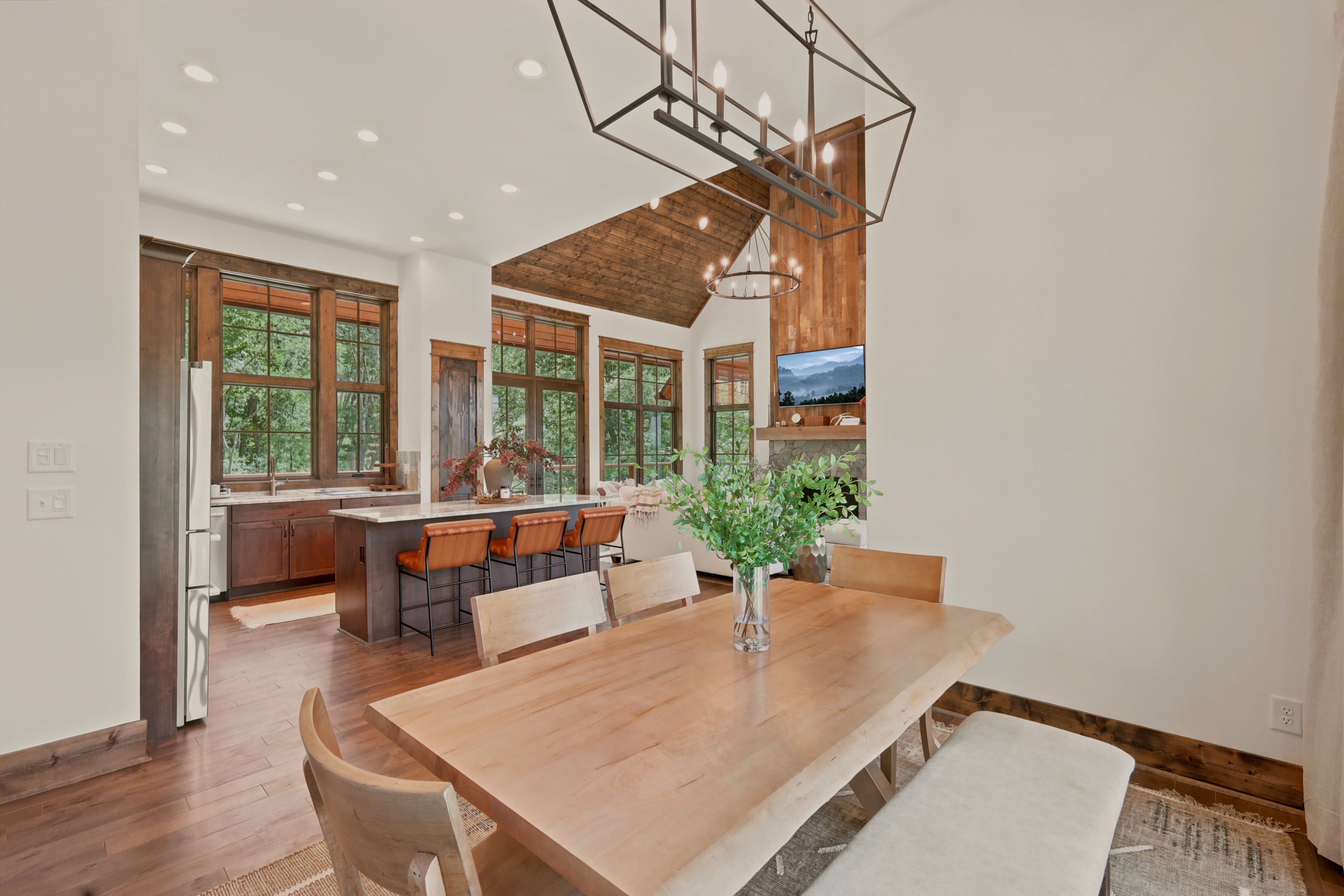 A spacious kitchen with a large island, wooden cabinets, and a dining area with a wooden table and chairs.