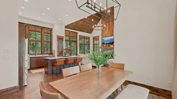 A spacious kitchen with a large island, wooden cabinets, and a dining area with a wooden table and chairs.