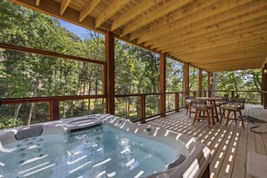 Um deck de madeira com hidromassagem e móveis de exterior.