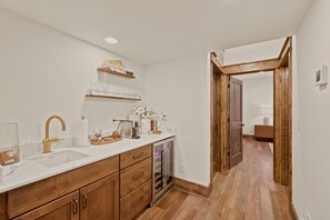 A modern kitchen with wooden cabinets, a white countertop, and a built-in oven. - Brand-New LUXE Creekside Cabin w Hot Tub, Fire Pit (Banner Elk)