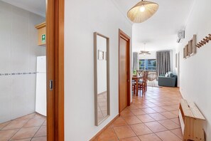 A corridor with a wooden door, a mirror, and a hanging light fixture. - Apartment '1E Apt Esteva' with Shared Pool, Wi-Fi and Air Conditioning (Santa Luzia)