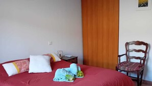 A bedroom with a red bedspread, a wooden chair, and a small bedside table. - Villa "La Farigoulo" with garden (Antibes)