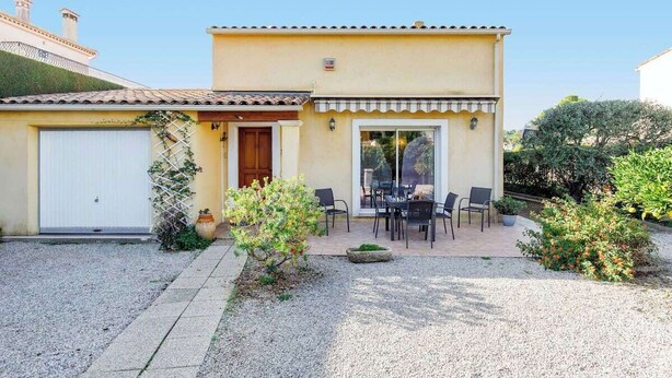 A two-story building with a covered patio area, a garage, and a garden with gravel paths. - Villa "La Farigoulo" with garden (Antibes)