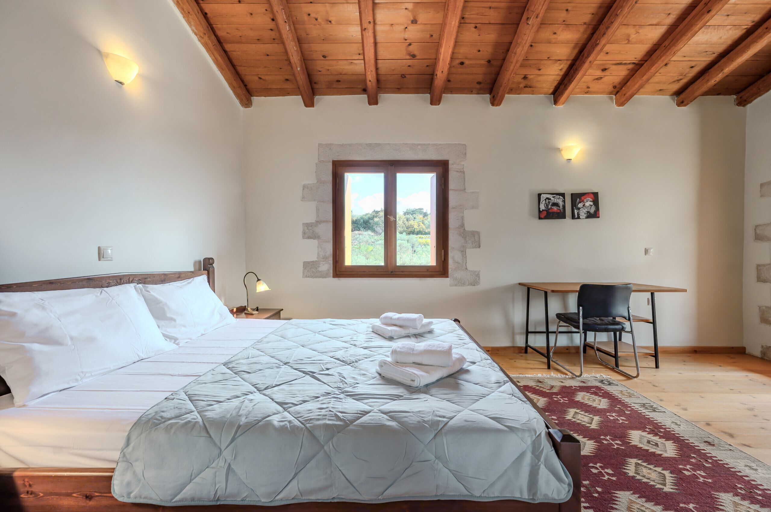 Une chambre à coucher avec un lit, un bureau et une fenêtre.