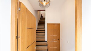 En trappe i træ med en moderne lampe over sig.