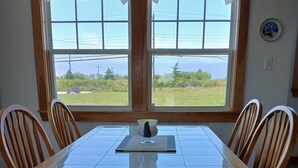 Comedor con una mesa grande, seis sillas de madera y vistas amplias por las ventanas.