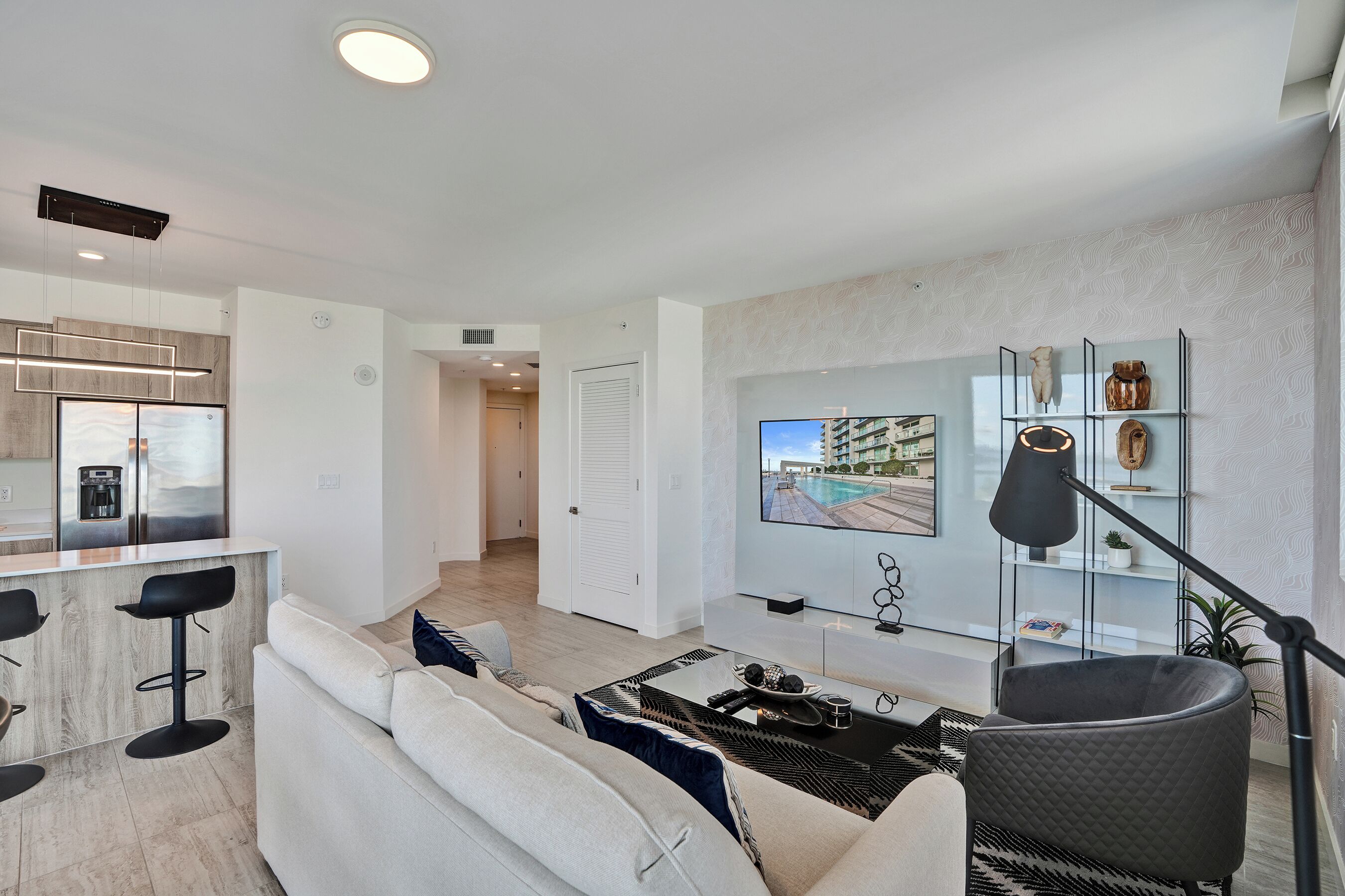 Un salon moderne avec un canapé, une table basse et un téléviseur fixé au mur.