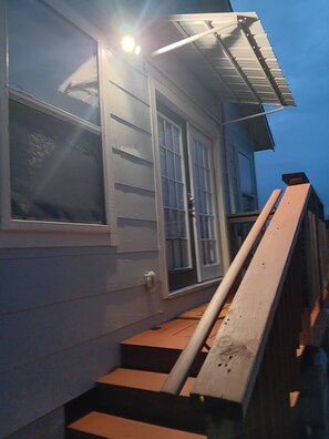 A residential building with a porch, a set of stairs leading to the entrance, and a door with glass panels. - Cozy 1-bedroom studio in charming Houston with AC (Houston)