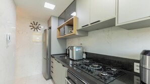 Une cuisine moderne équipée d’une cuisinière à gaz, d’un four encastré, d’un réfrigérateur et d’un four à micro-ondes.