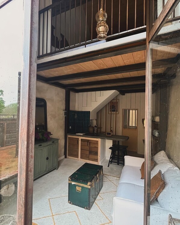 A cozy interior with a wooden staircase, a dining area, and a seating space. - Domaine du Tertre ychot (Dol-de-Bretagne)