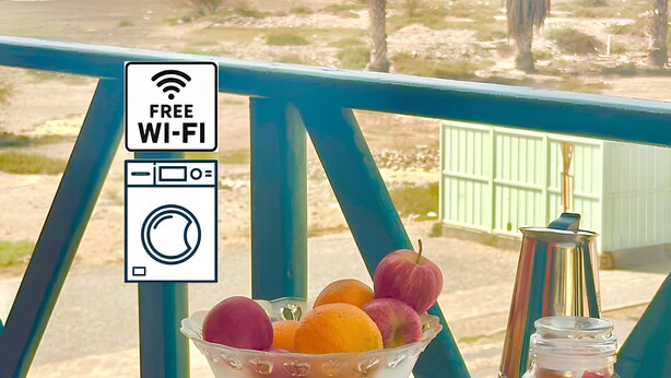 Taula amb menjar per esmorzar, vistes a la platja i un cartell de Wi-Fi gratuït.