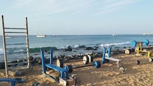 Una platja amb aparells de musculació improvisats i una escala.