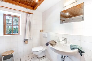 A bathroom with a toilet, sink, and window. - Holiday Home 'Ole Schün Dannau' with Private Terrace, Private Garden and Wi-Fi (Oldenburg in Holstein)